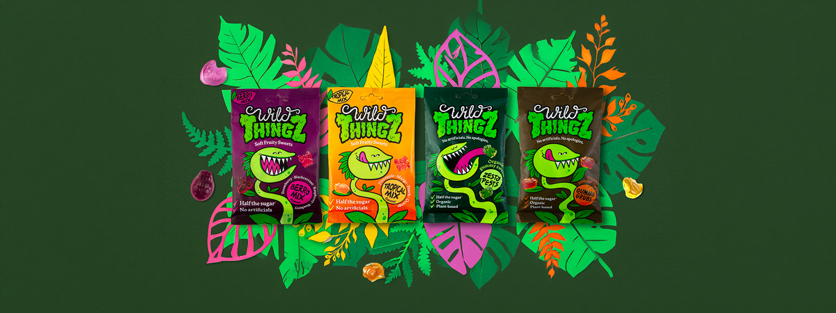 The four Wild Thingz packs, Berry Mix, Tropical Mix, Organic Zesty Pests and Organic Gummy Grubs, with gummies on an illustrated jungle background