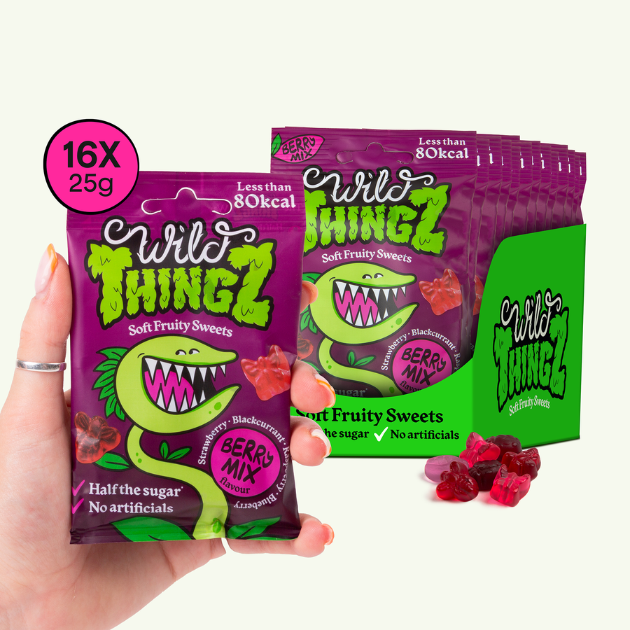 Hand holding a 25g bag of Wild Thingz Berry Mix in front of a case of 16 bags