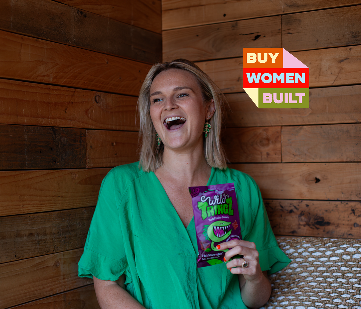 Fliss, founder of Wild Thingz, laughing and holding a bag of Berry Mix